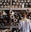 a woman standing in front of rolls of fabric